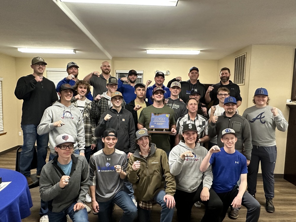 Picture of the 2022 La Grande High School Baseball 4A State Champions-players and coaches are showing the championship rings that they earned