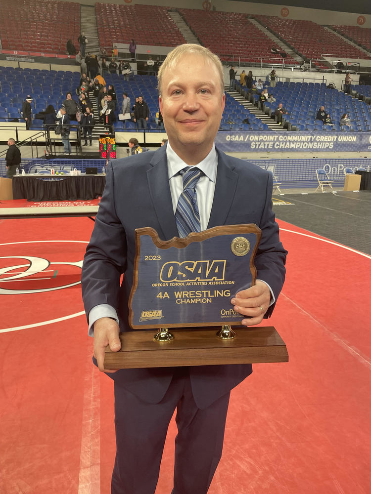 Photo of Klel Carson holding 4A State Wrestling Champion award