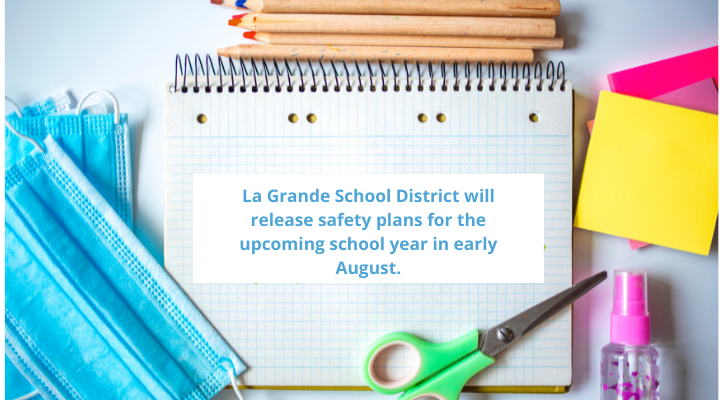 Image of pencils, paper, scissors, and masks.  On notepad it says, "La Grande School District will release safety plans for the upcoming school year in early August.